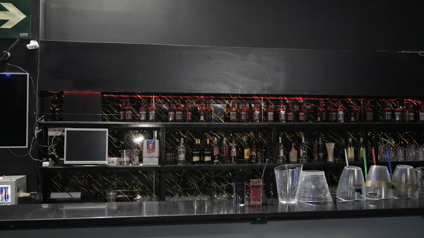 Barra de EPHIK con botellas y acabados negros con vetas doradas.