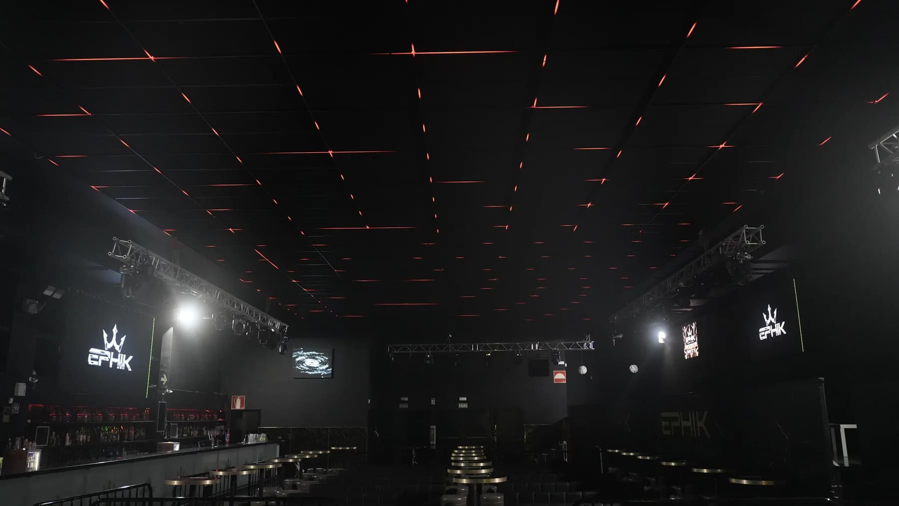 Sala de EPHIK con mesas, barra lateral y líneas de luz roja en el techo.
